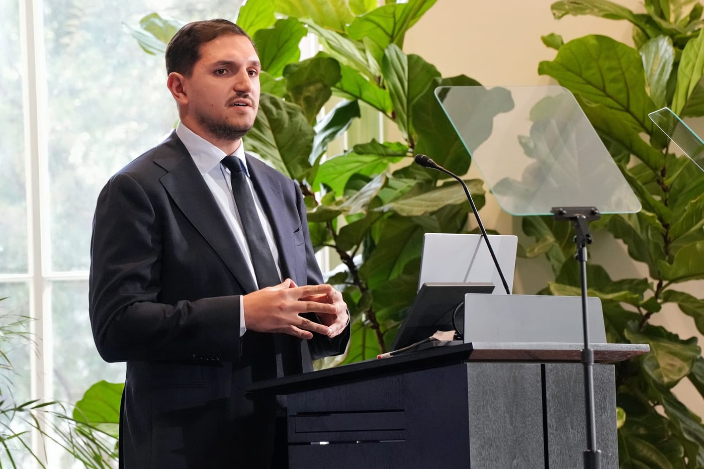 RiskCube founder and CEO Andrei Craciunescu speaking at the podium during Y Combinator's The Startup Industrial Base event in Washington, DC